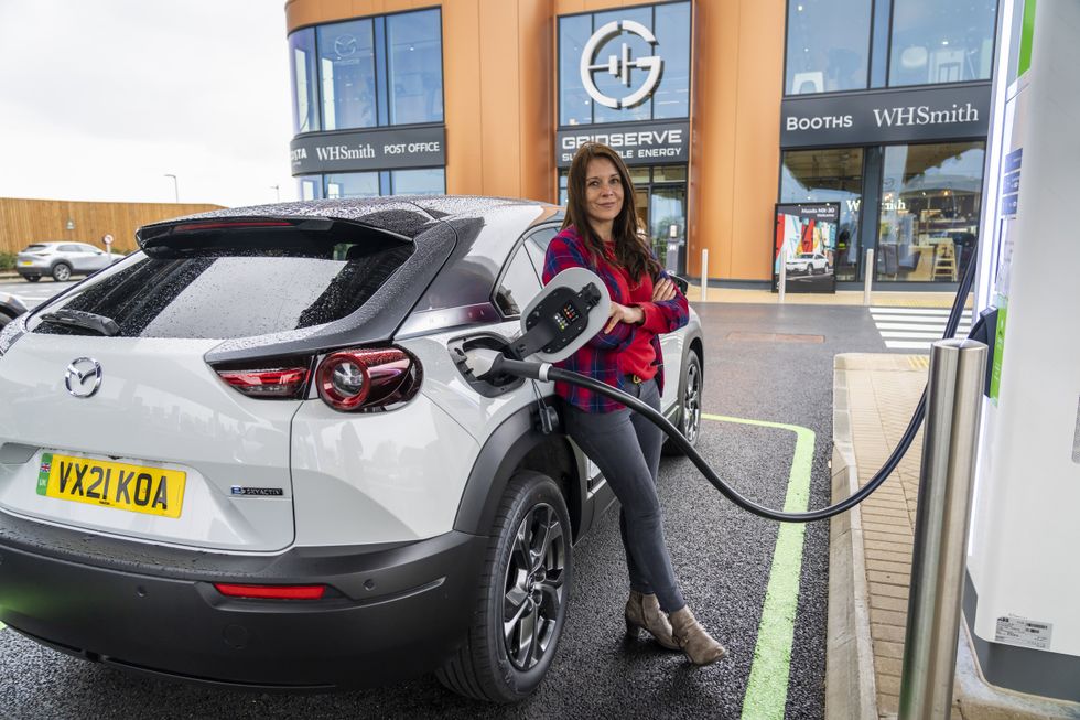 Ginny Buckley, fundadora da Electrifying.com, carrega um veículo elétrico