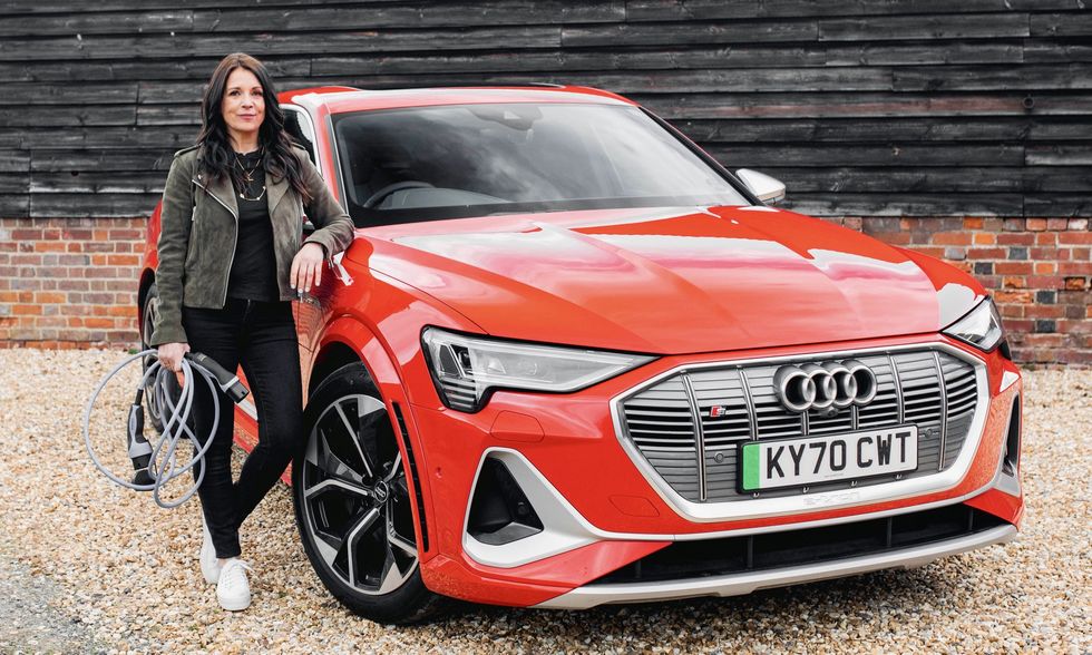 Ginny Buckley, fundadora da Electrifying.com, carrega um veículo elétrico