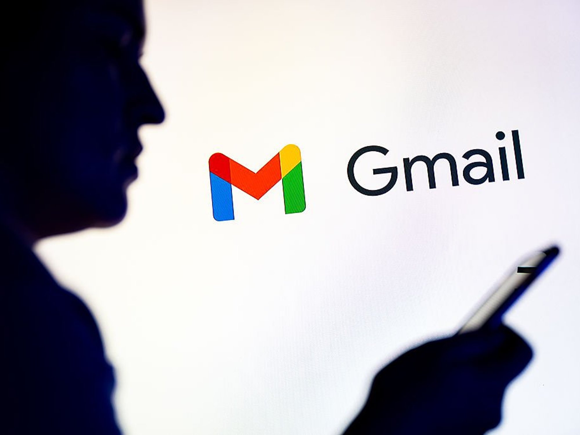Gmail logo behind person holding handset