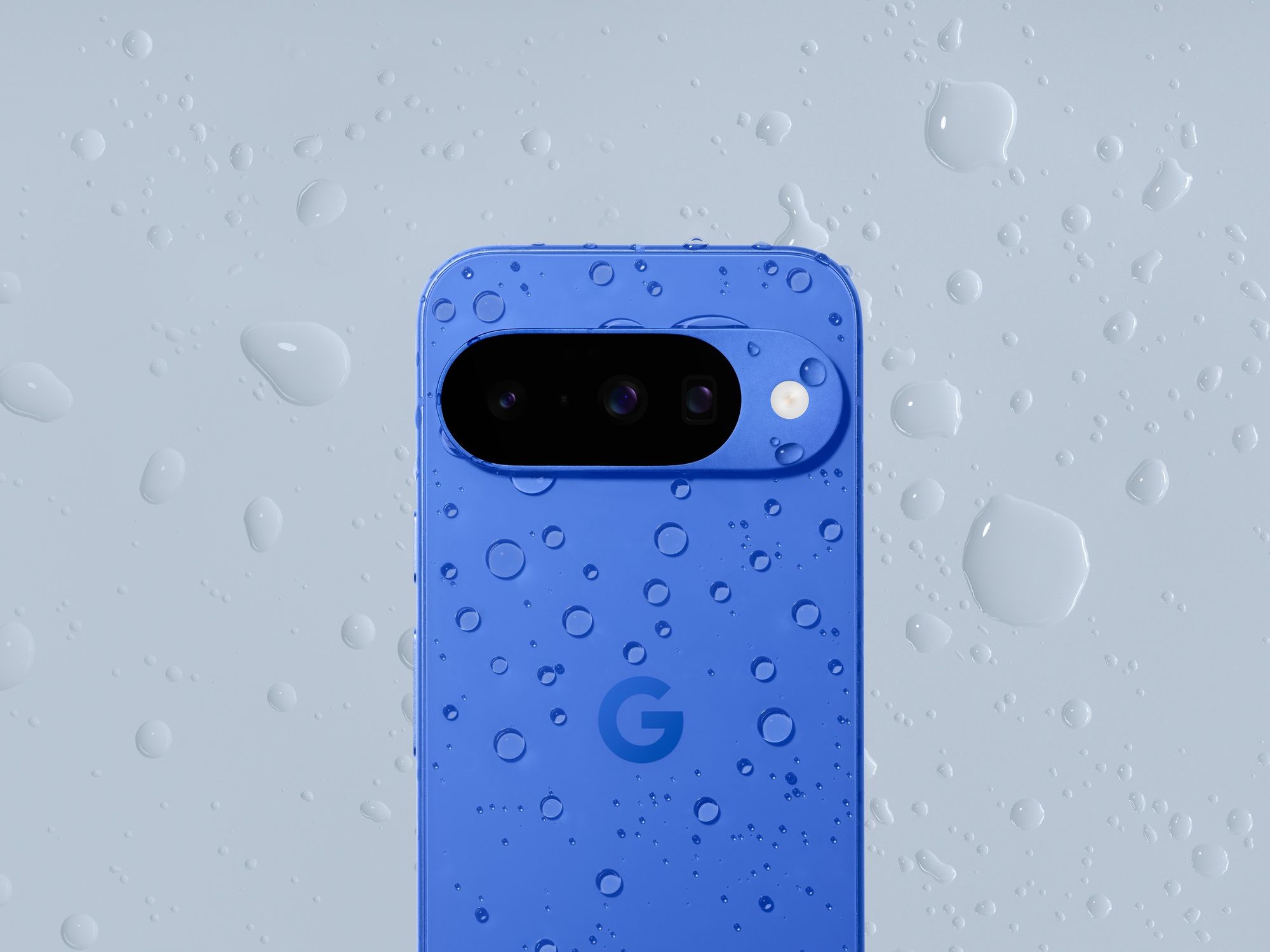 Google Pixel 10 shown in indigo with rain splattering it