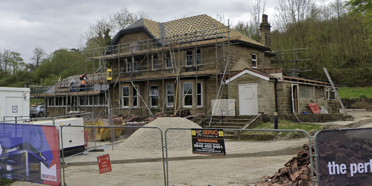 NextImg:Neighbour row sees homeowners hoist banner next to McDonald's after fast food chain destroyed her fence