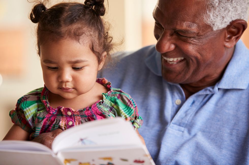 Grandparent and grandchild reading a book together