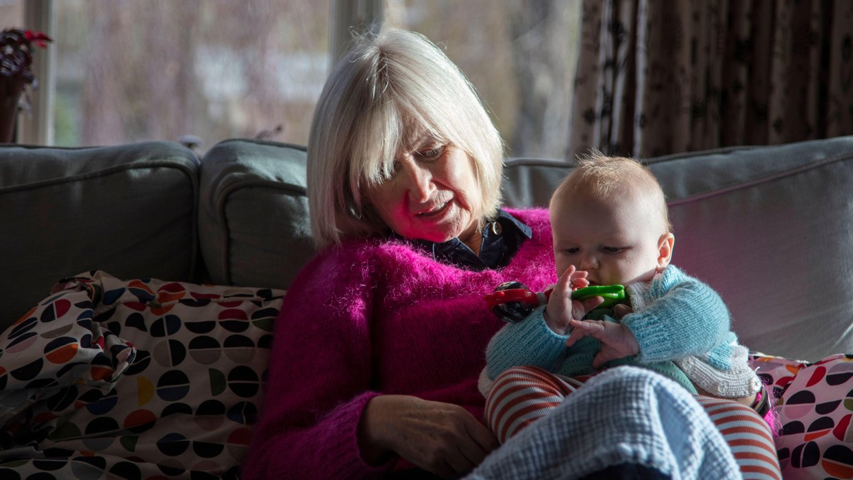 Grandparent and grandchild sitting on sofa together