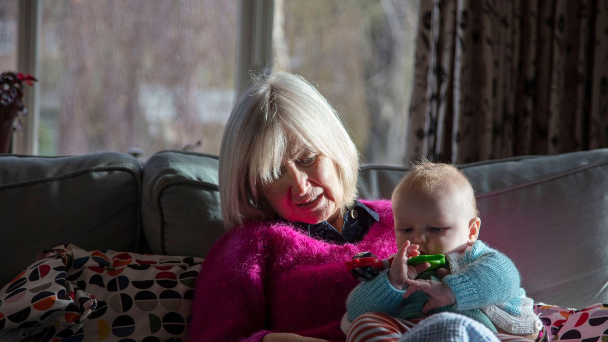 Grandparent and grandchild sitting on sofa together