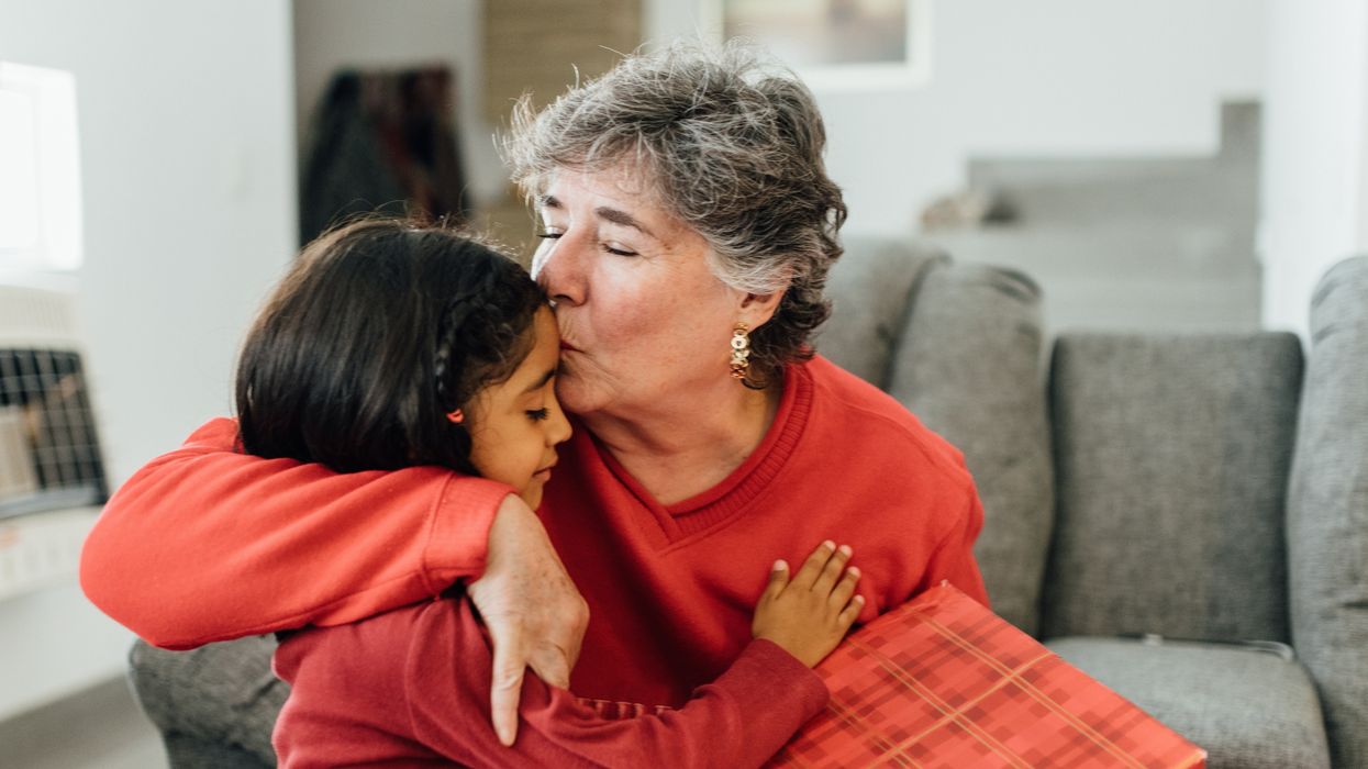 Grandparent embraces grandchild and gives them a gift