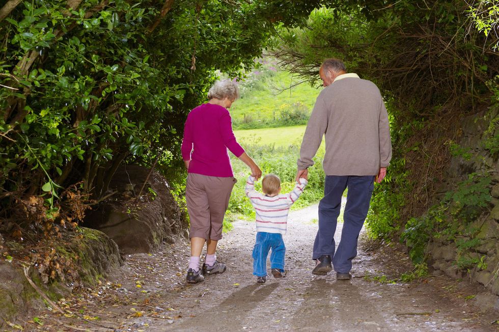 Grandparents and child going for a walk with their grandchild in nature