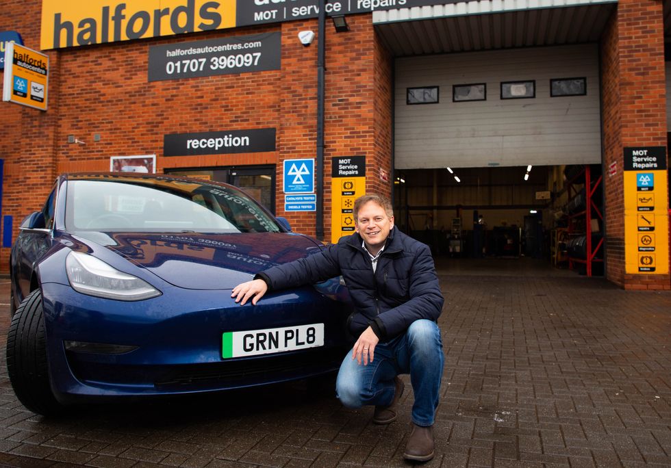 Grant Shapps with a green number plate electric car