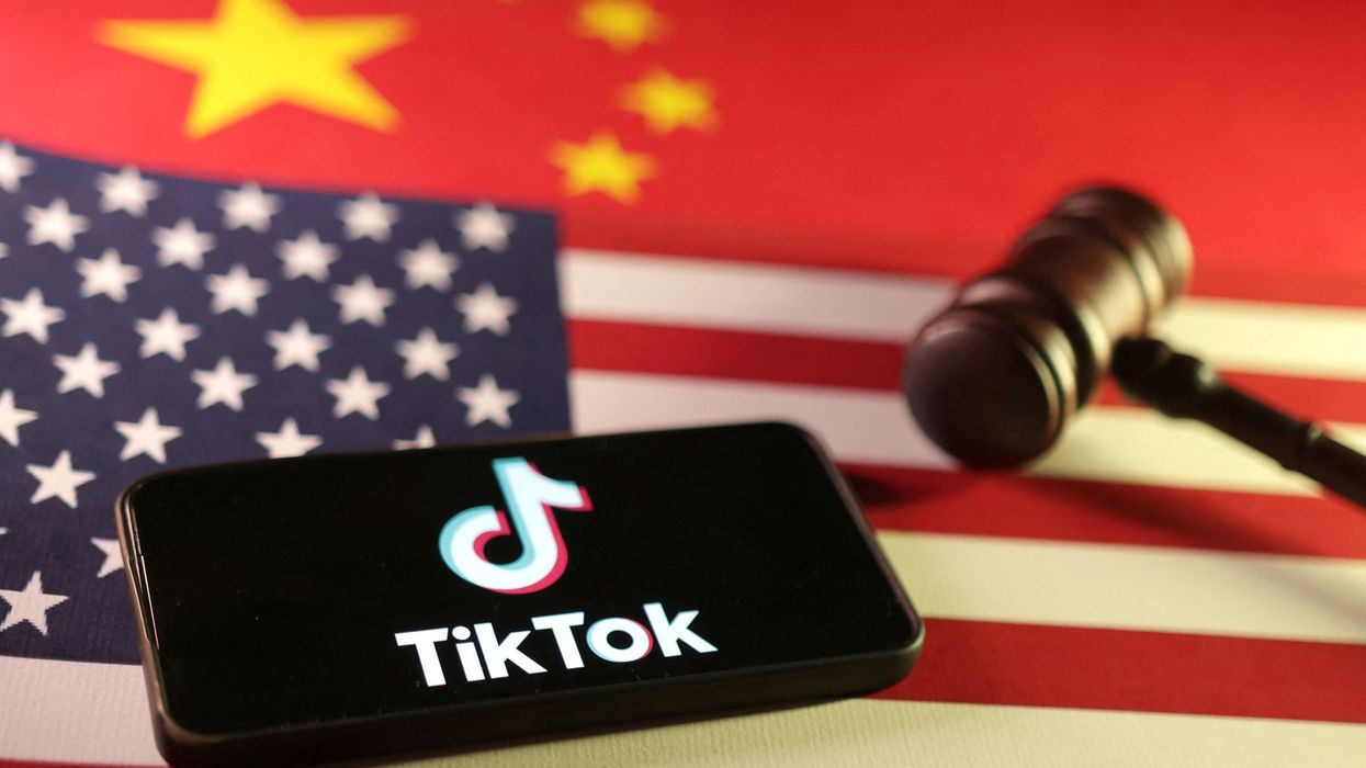 gravel on the USA flag with a smartphone with the TikTok logo on-screen