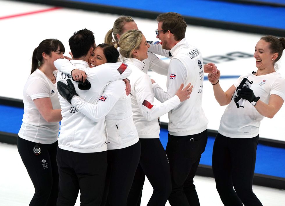 Great Britain coach David Murdoch, Eve Muirhead, Vicky Wright, Jennifer Dodds, Hailey Duff, Mili Smith and coach Kristian Lindstrom celebrate winning gold in the Women's Gold Medal Game during day sixteen of the Beijing 2022 Winter Olympic Games at the National Aquatics Centre in China.