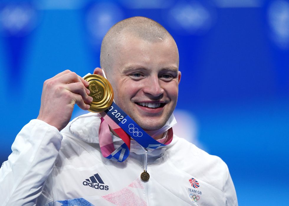 Great Britain's Adam Peaty poses with his gold medal on the podium after winning the Men's 100m Breaststroke final at the Tokyo Aquatics Centre on the third day of the Tokyo 2020 Olympic Games in Japan. Picture date: Monday July 26, 2021.