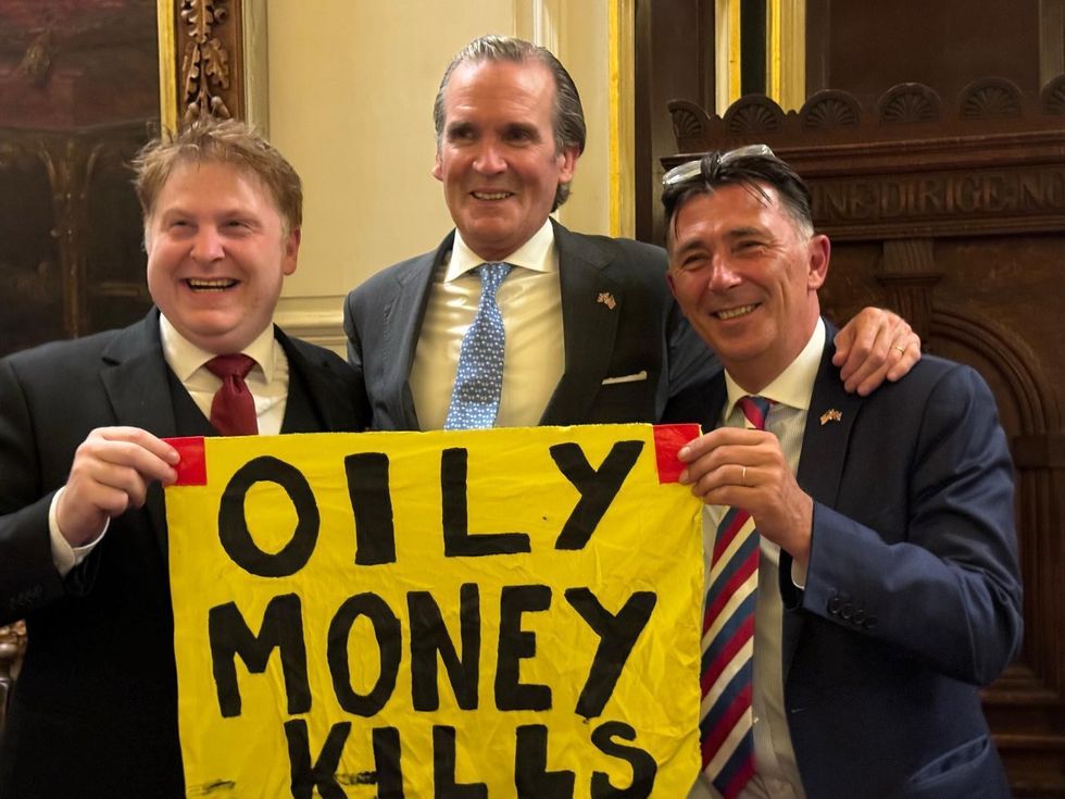 Gregg Swenson and diners with 'oily money kills' banner
