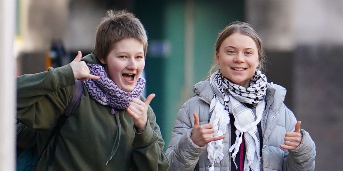 NextImg:Greta Thunberg GRINS as she POSES for cameras while arriving at court after being charged over eco-protest