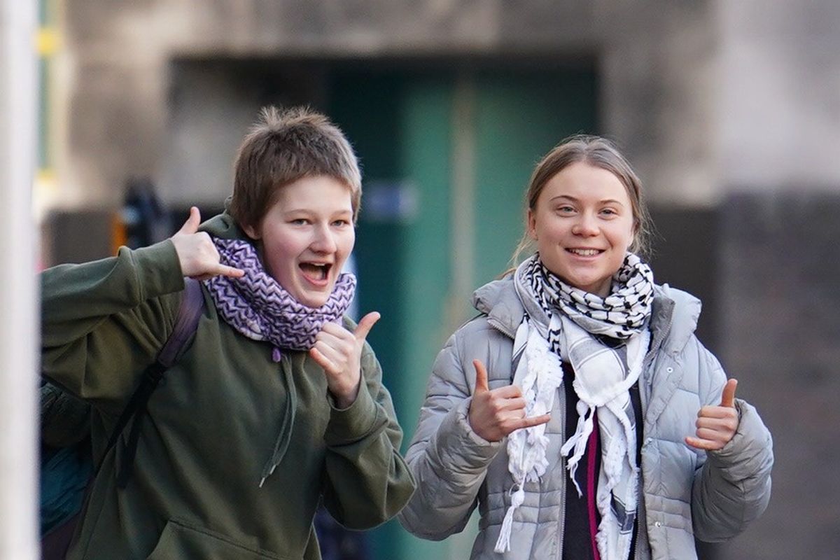 ​Greta Thunberg poses and smiles in front of the camera while arriving at court over eco-protest