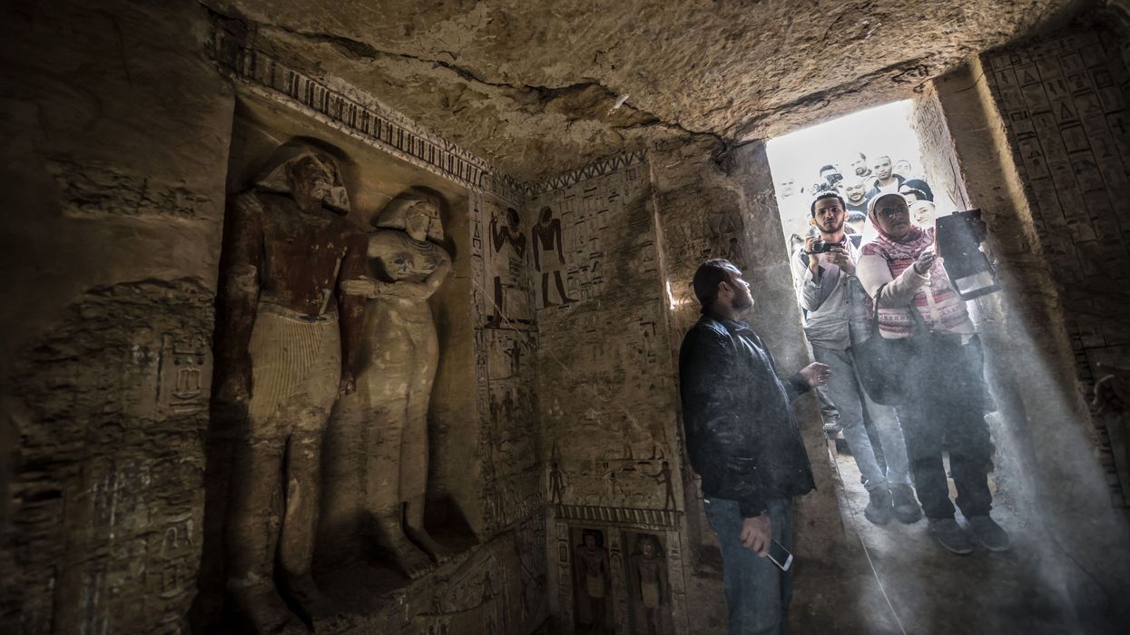 Guests enter a newly-discovered tomb at the Saqqara necropolis