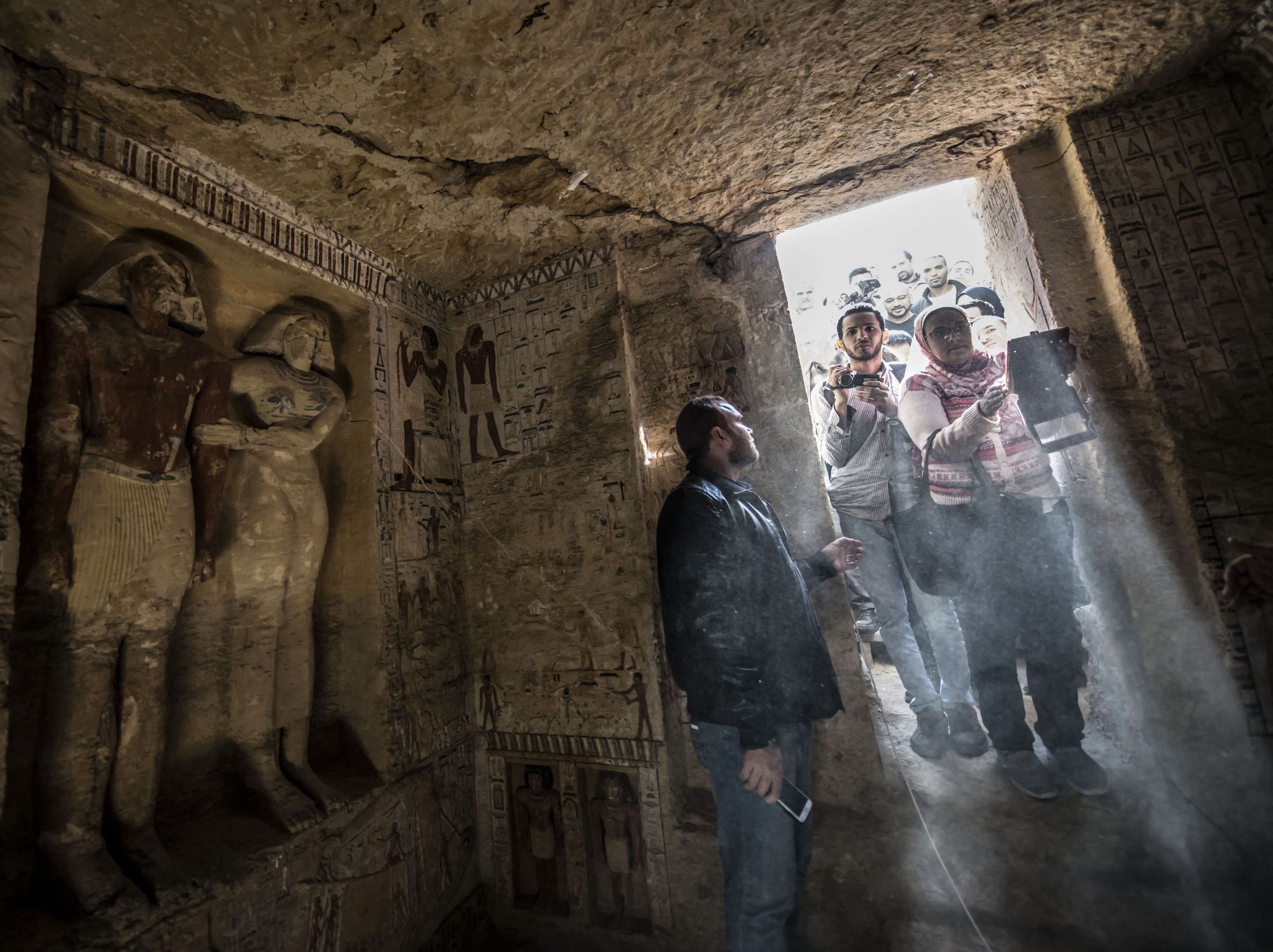 Guests enter a newly-discovered tomb at the Saqqara necropolis