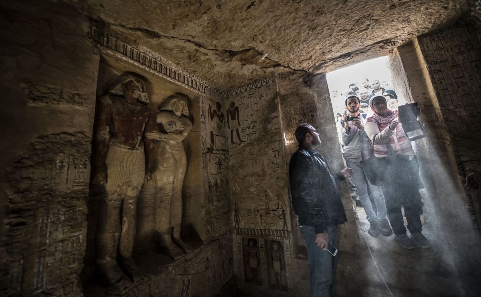 Guests enter a newly-discovered tomb at the Saqqara necropolis