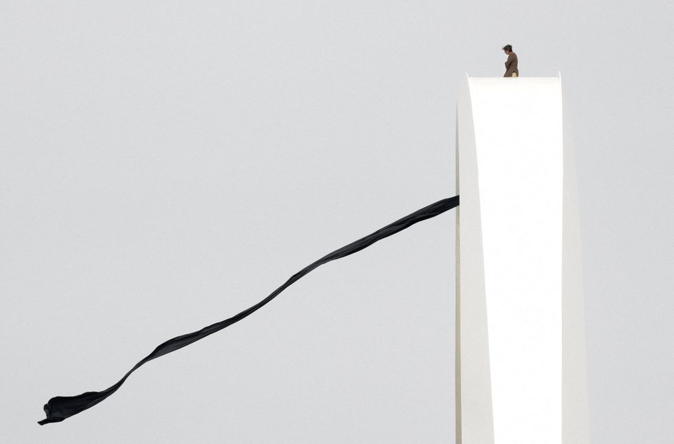 Guido Reichstadter, unfurling a long black banner on the Frederick Douglass Memorial Bridge in Washington