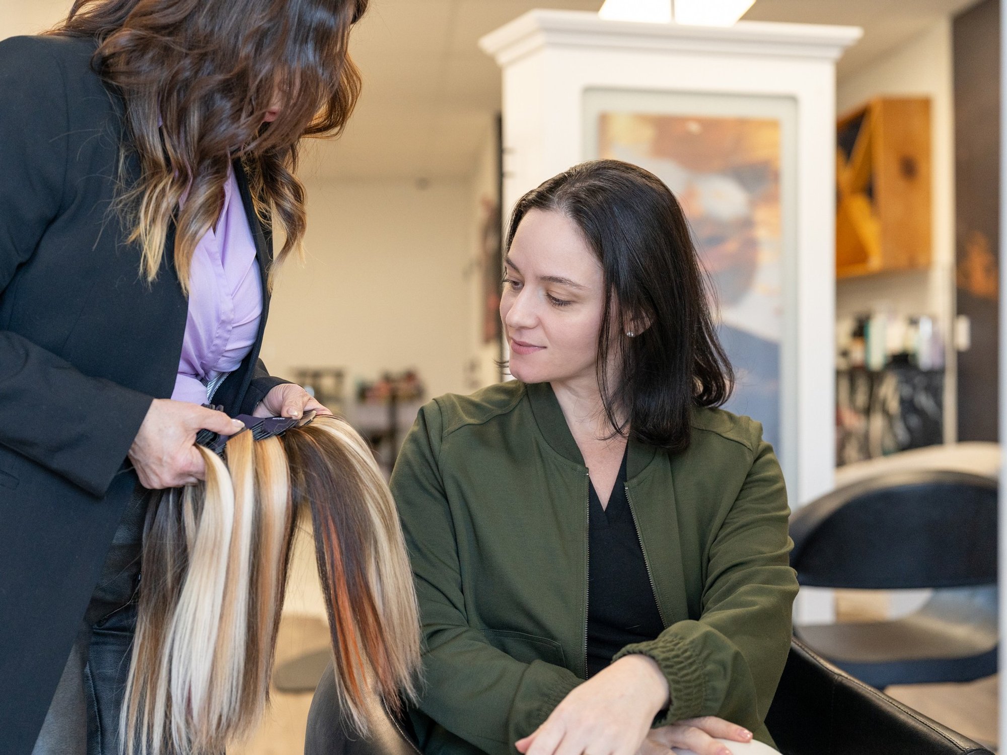 Hairstylist showing female customer extensions