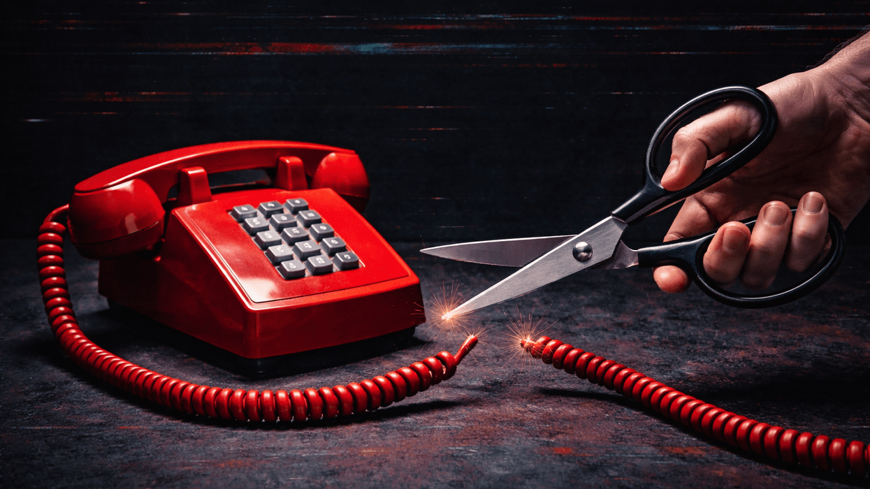 Hand cutting hold scissors that have cut the cord of a landline phone