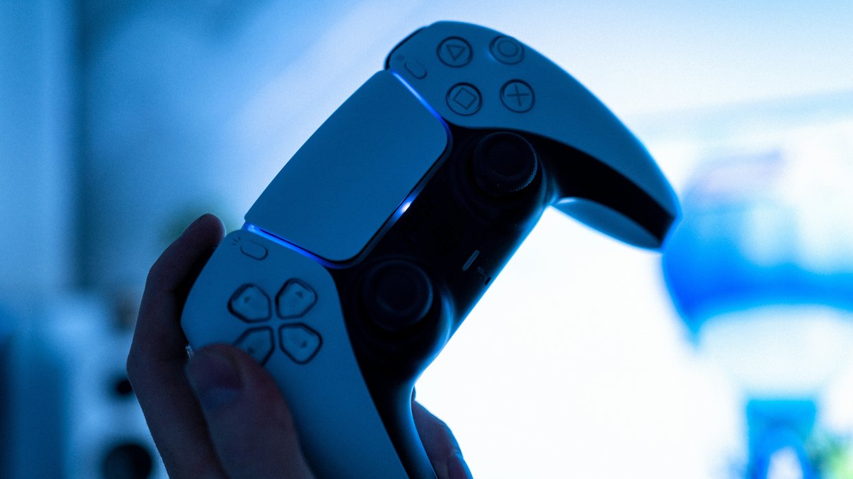 hand holding a playstation 5 controller