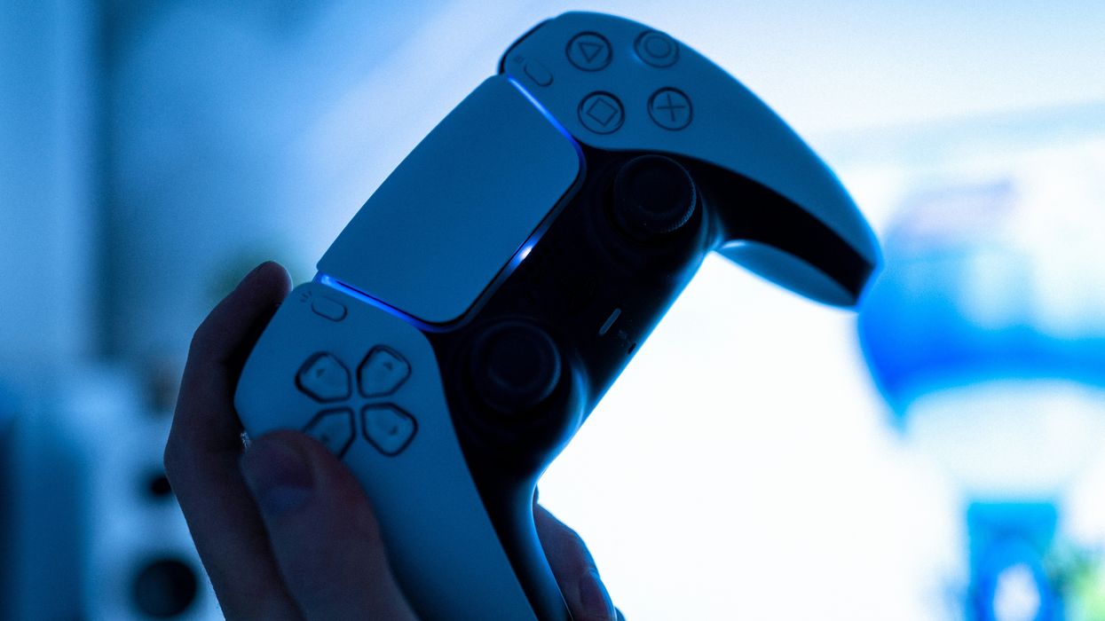 hand holding a playstation 5 controller