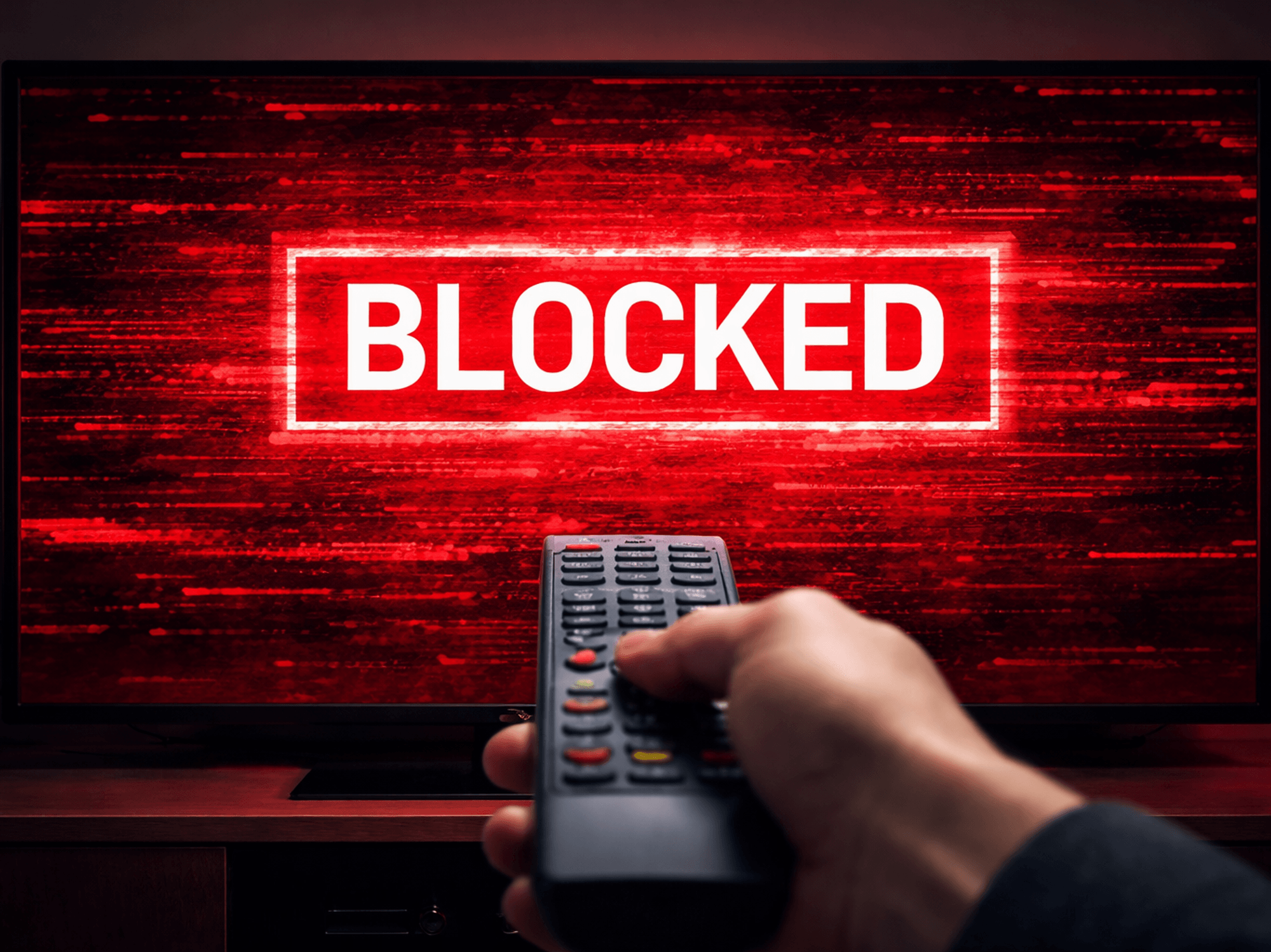 Hand holding a remote in front of a TV blocked from streaming content