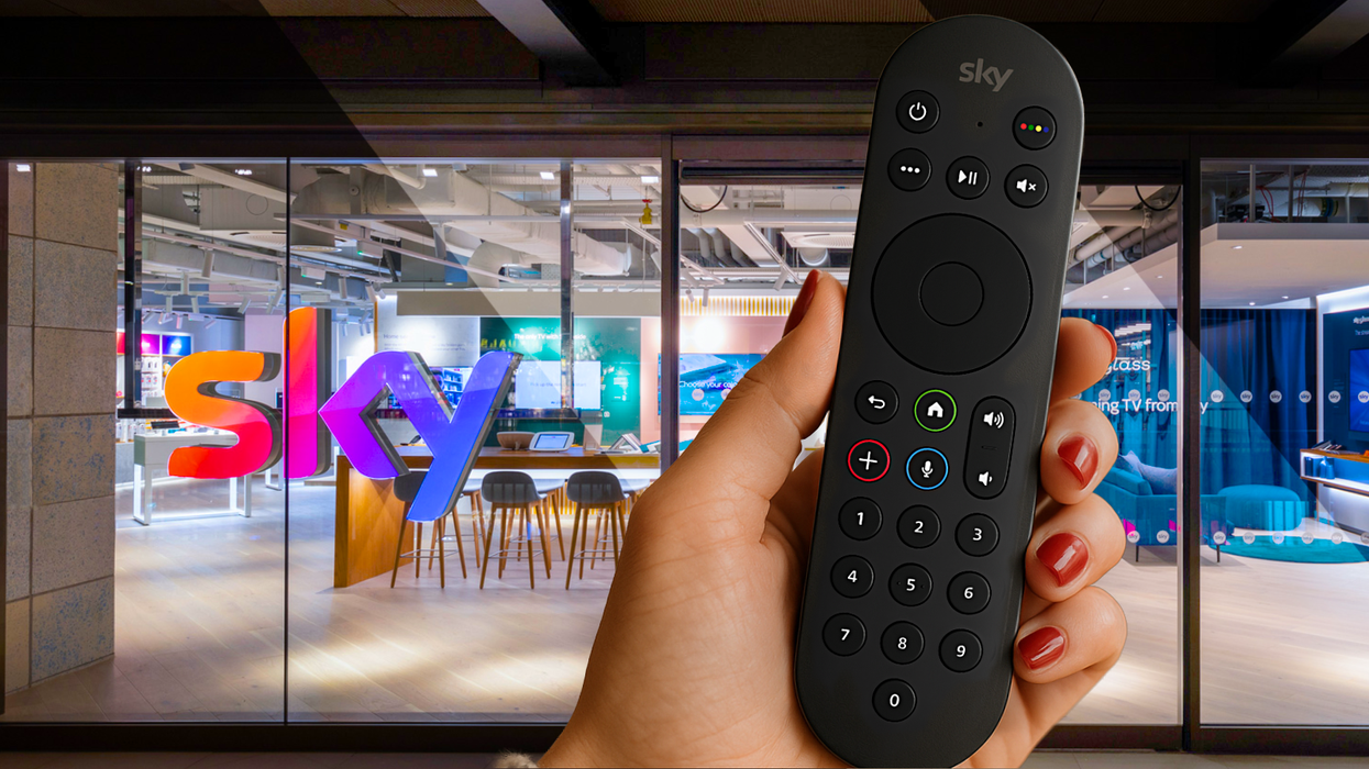 hand holding a sky tv remote with the battersea flagship sky store in the background