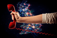 hand holding a traditional landline phone in red with a map of the UK with broadband connections in the background.
