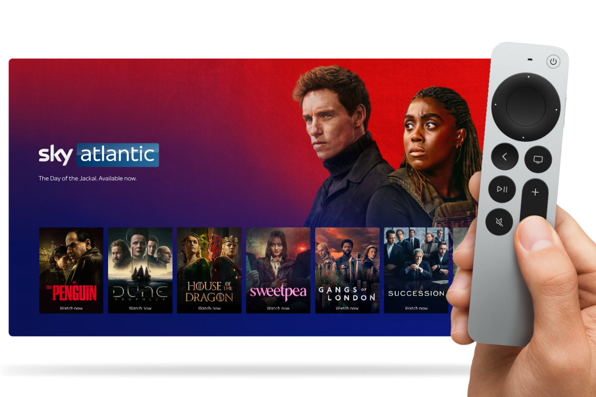 hand holding an apple tv remote control with a screen showing sky atlantic shows in the background