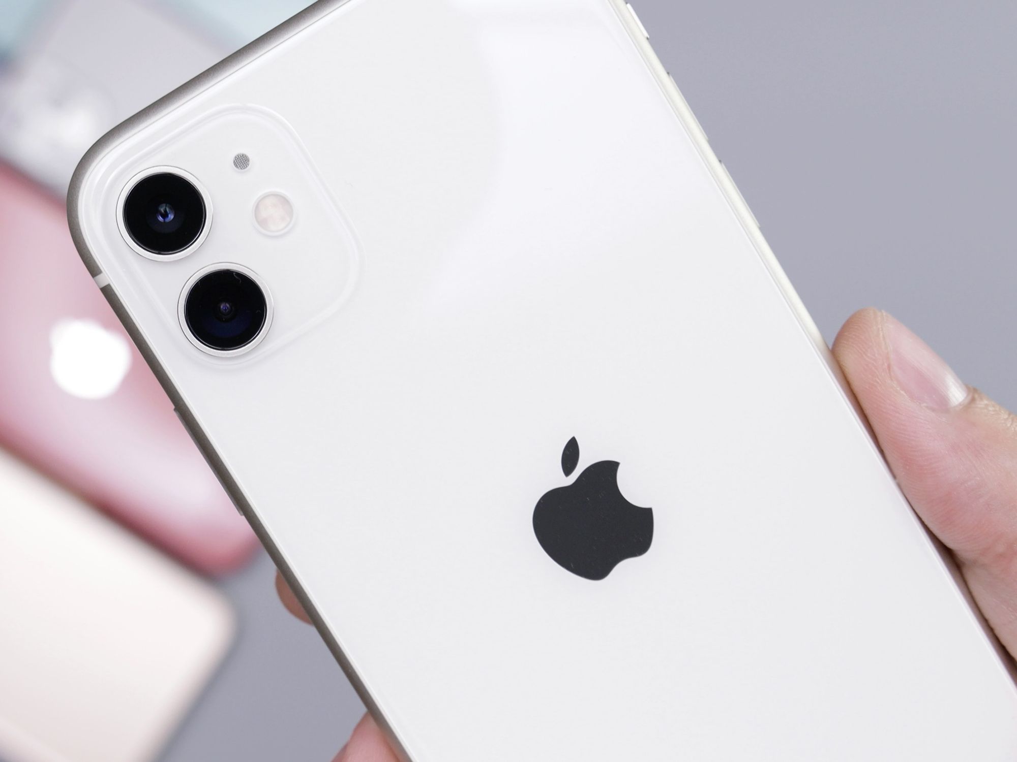hand holding an iphone 11 with the other colours in the background