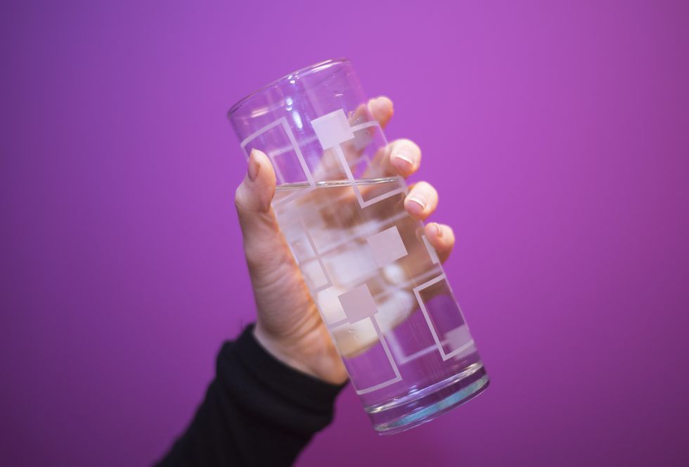 The hand holding a glass of water