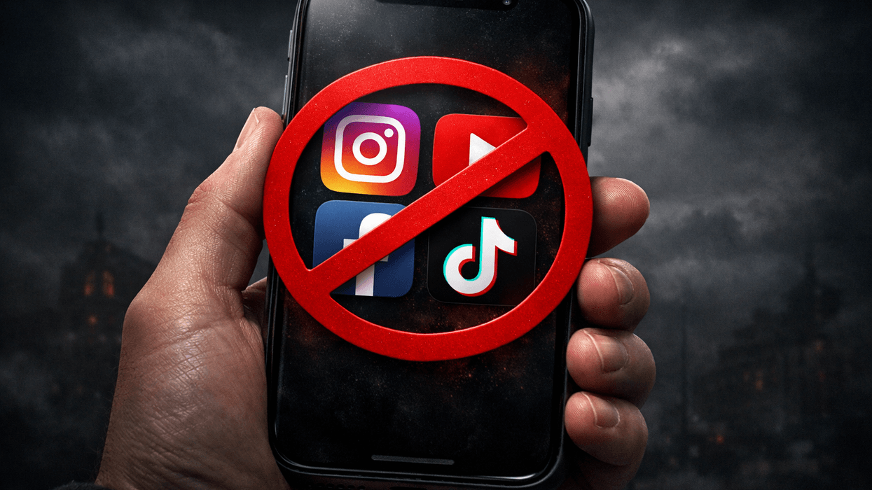 Hand holding mobile with four social media app icons displayed with red block symbol