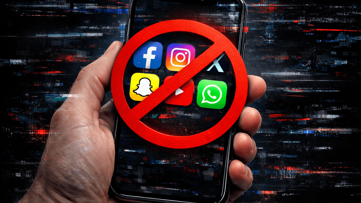 Hand holding mobile with social media app icons displayed with red block symbol