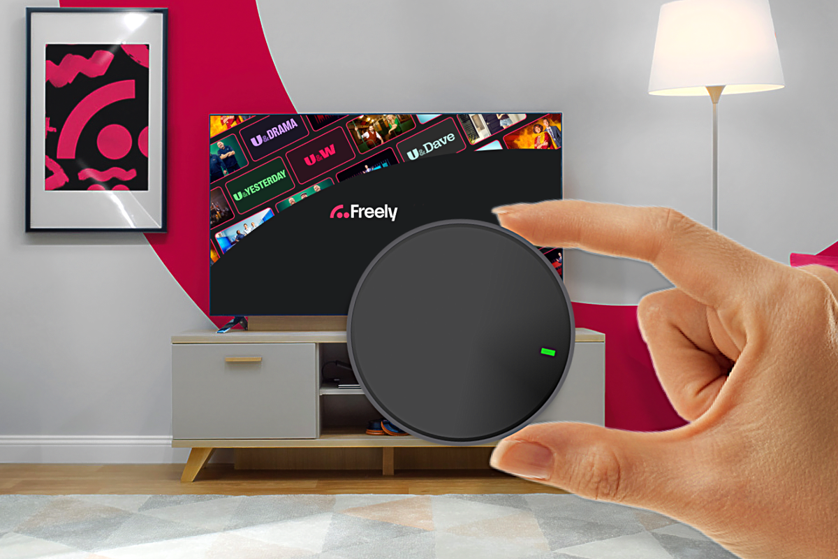 hand holding streaming puck with Freely in the background