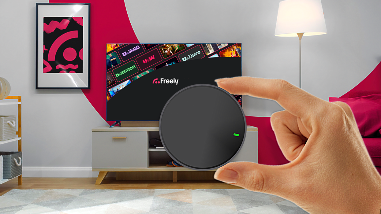 hand holding streaming puck with Freely in the background