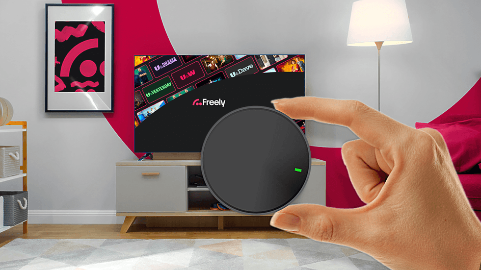 hand holding streaming puck with Freely in the background