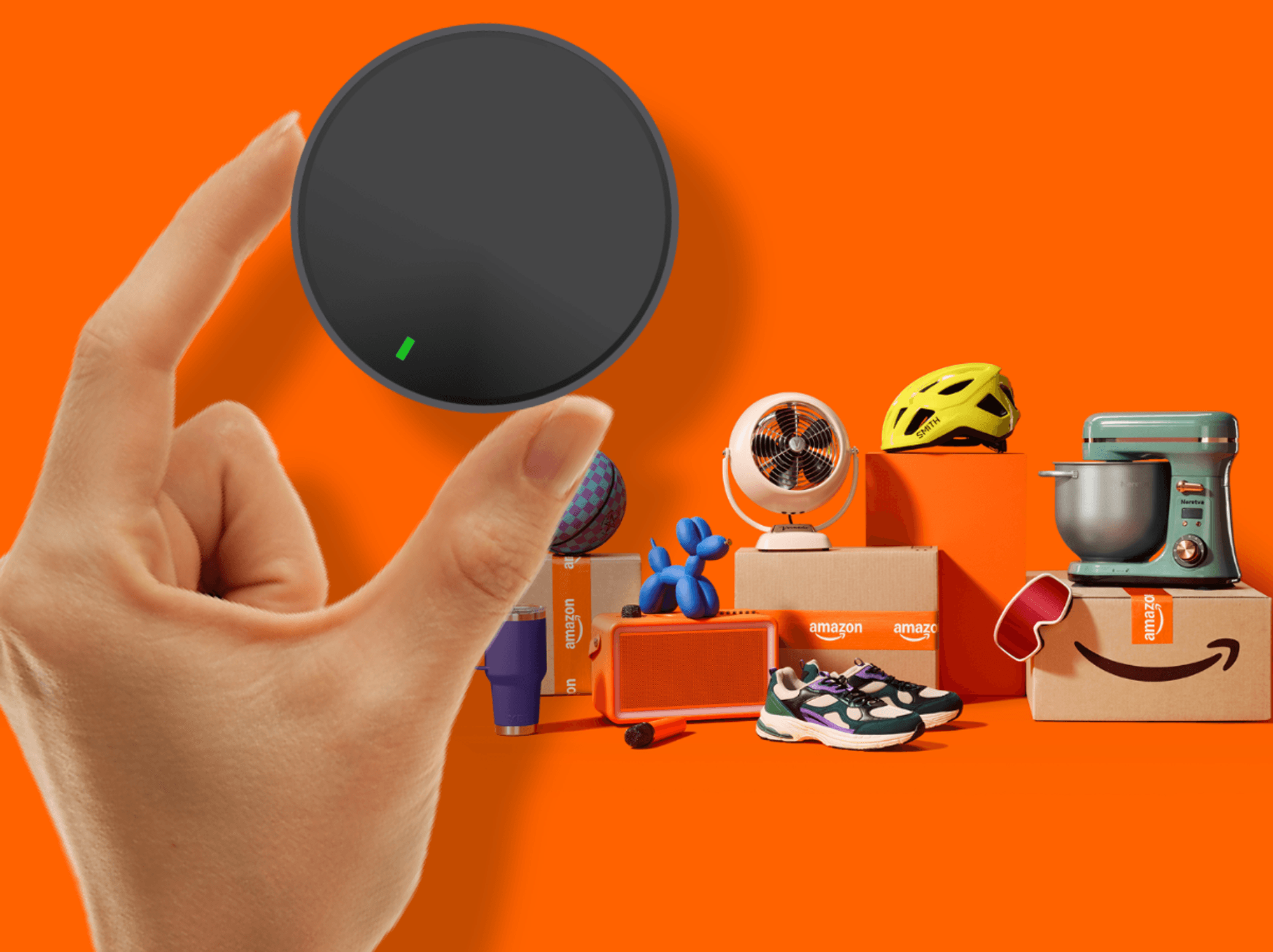 Hand holding streaming puck with other products and Amazon packaging in the background