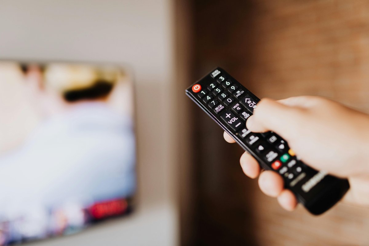 Hand holding TV remote