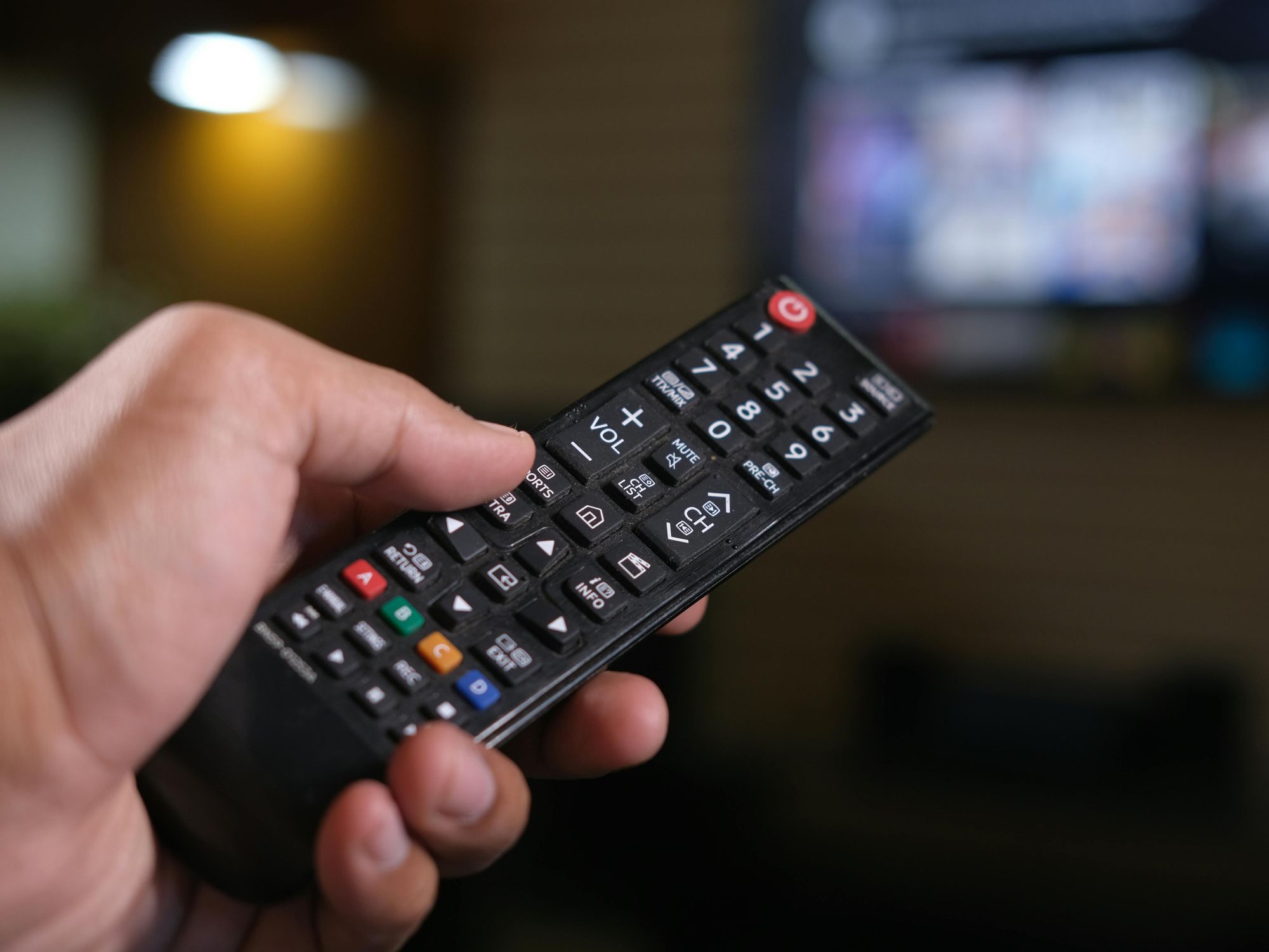 Hand holding TV remote