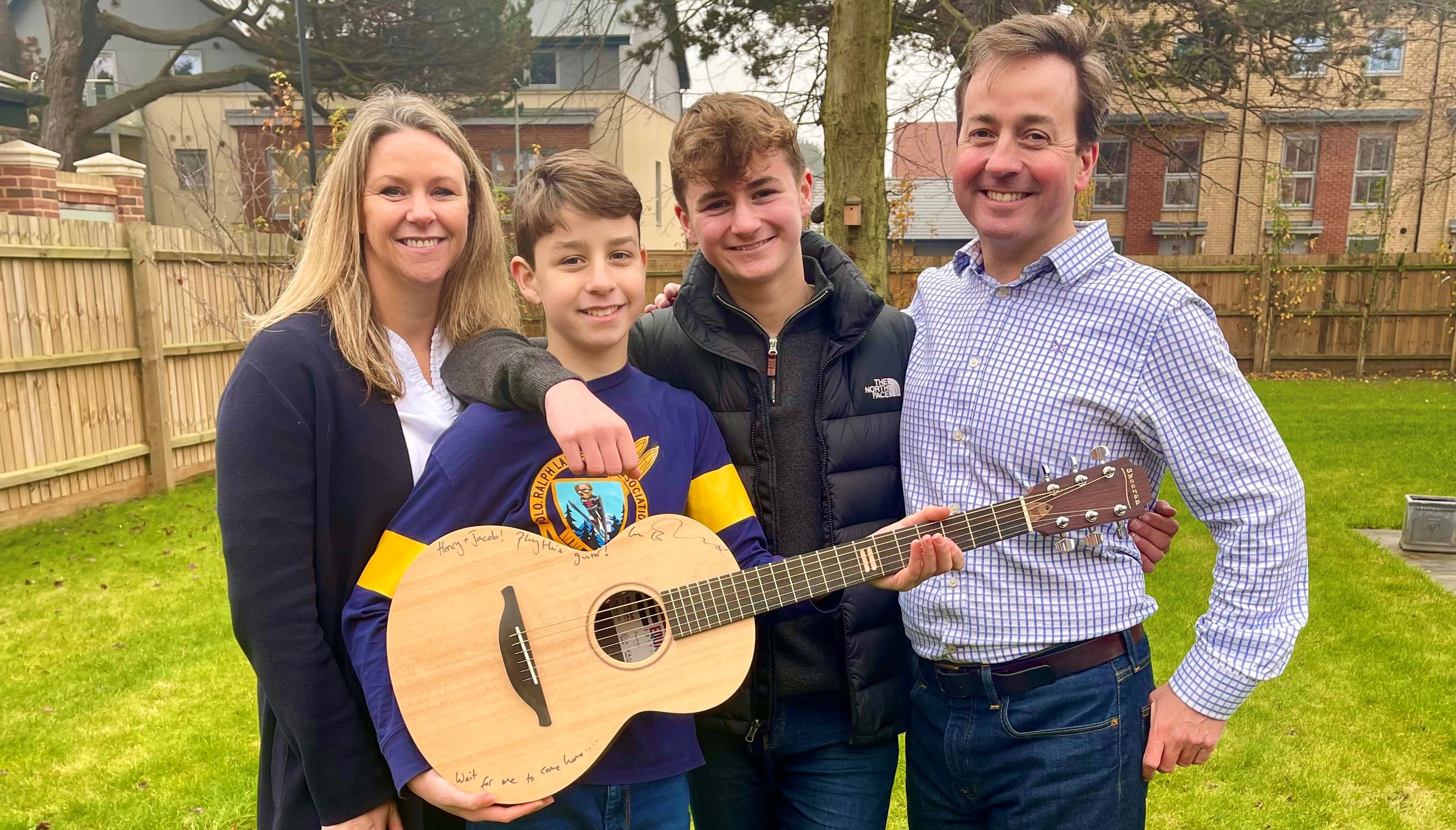 Handout photo issued by GeeWizz of hospital worker Kellie Myers from Ipswich with her two sons Henry, 14, and 13-year-old Jacob and husband Graham as they hold Ed Sheeran's prototype Equals guitar which she won in a charity raffle. Issue date: Friday December 24, 2021.
