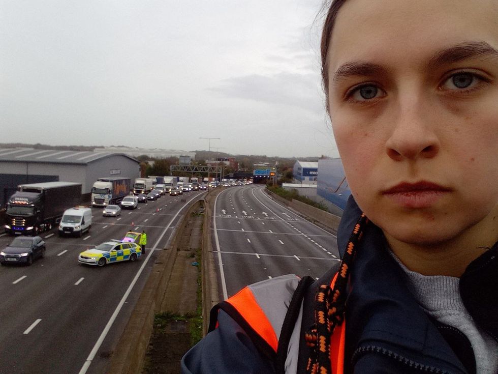 Handout photo issued by Just Stop Oil of a protester who has climbed a gantry on the M25 between junctions six and seven in Surrey, leading to the closure of the motorway. Surrey Police said the decision was made to close the road %22for the safety of everyone%22 while officers attempt to remove the activist. Picture date: Monday November 7, 2022.