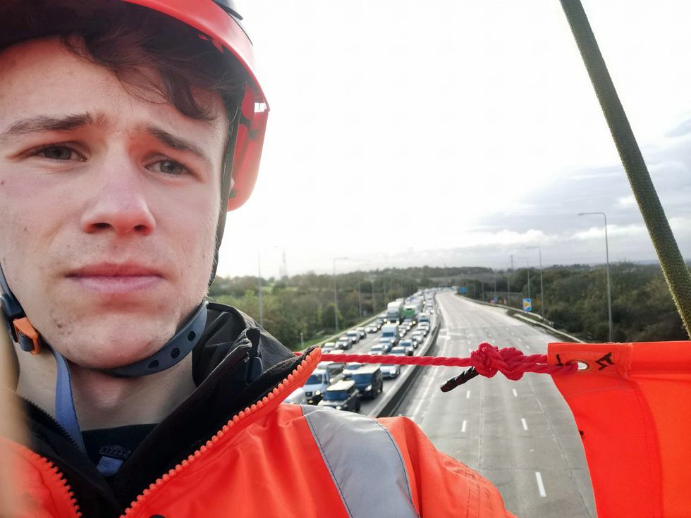 Handout photo issued by Just Stop Oil of an activist on a overhead gantry on the M25 which has been closed by police due to ongoing protests from the group. Just Stop Oil said around 10 of its supporters climbed onto overhead gantries in %22multiple locations%22 on the M25 from 6.30am on Wednesday, in what is the third consecutive day of protests on the UK's busiest motorway. Issue date: Wednesday November 9, 2022.