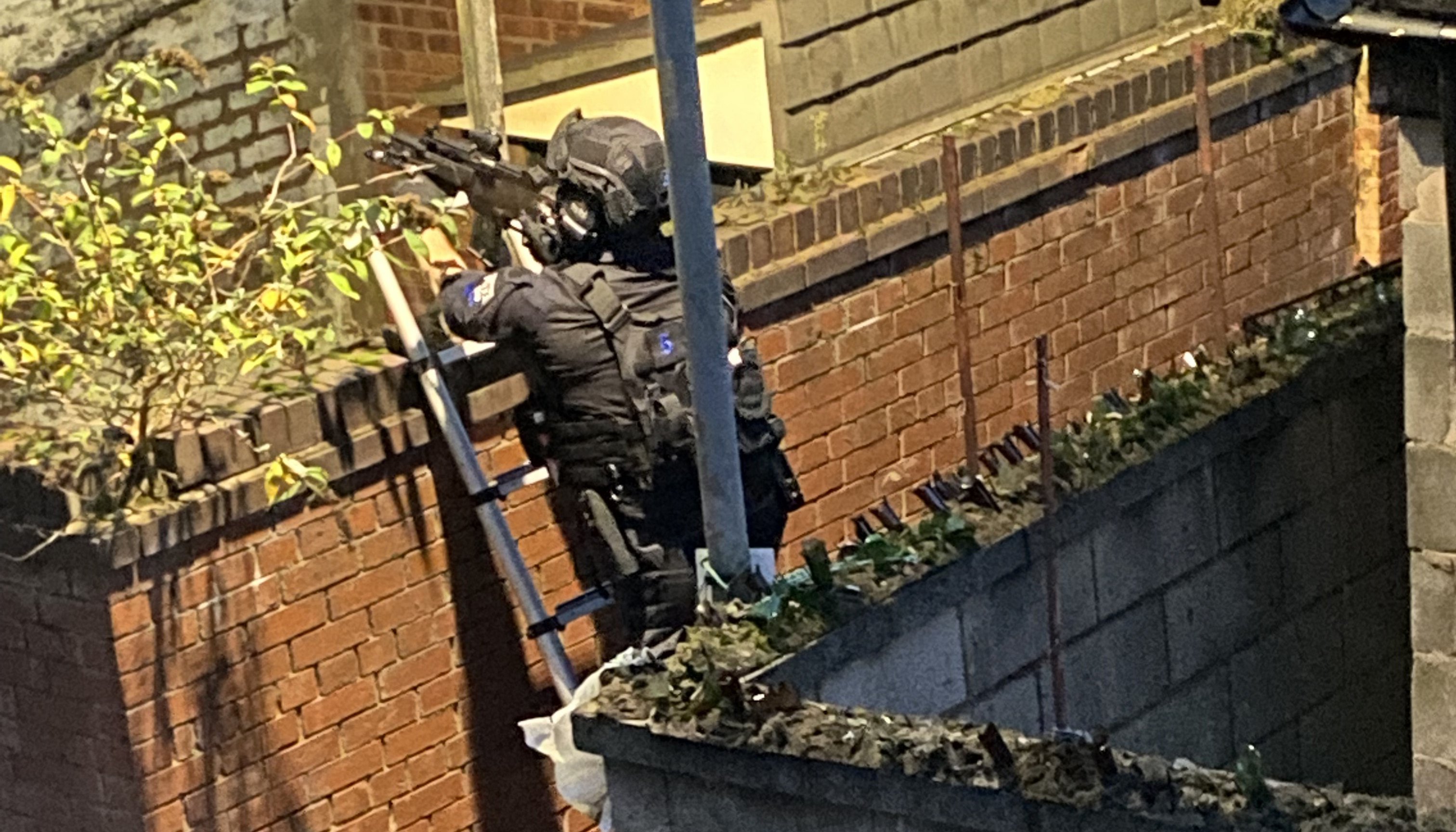 Handout photo of an armed police officer at the rear of a property in Sutcliffe Street in the Kensington area of Liverpool, after an explosion at the Liverpool Women's Hospital killed one person and injured another. Picture date: Monday November 15, 2021.