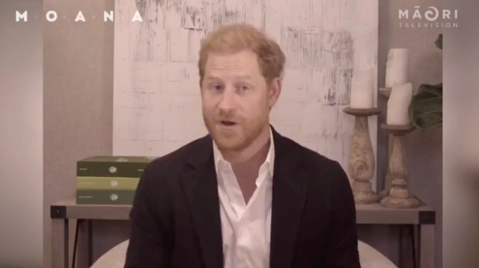 Harry is seen sat in front of a desk, complete with candles and books.
