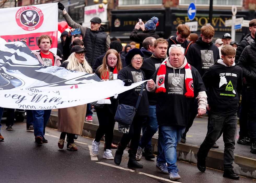 Harvey Willgoose's father Mark Willgoose holds a banner as he marches to Bramall Lane in memory of his son\u200b