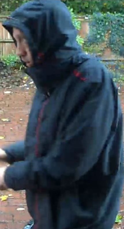 He was seen wearing a raincoat with red stripes, black tracksuit bottoms, and grey trainers