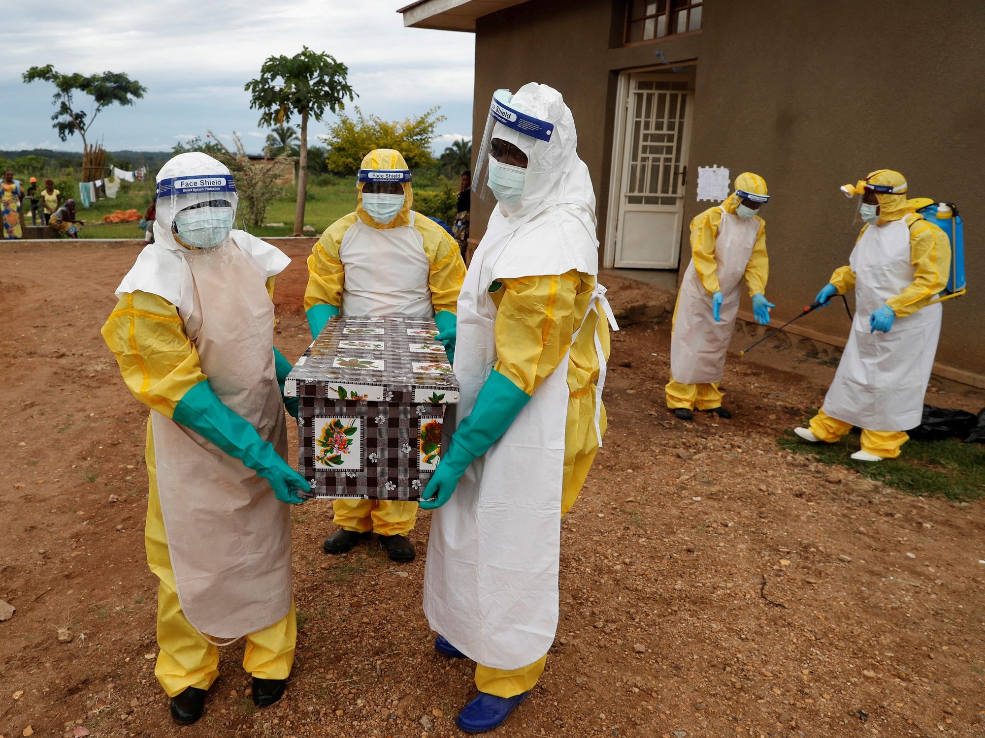 Healthcare workers carry a coffin with a baby, suspected of dying from Ebola