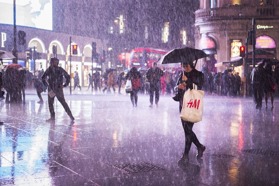 Heavy rain sweeps over Piccadilly Circus in London.