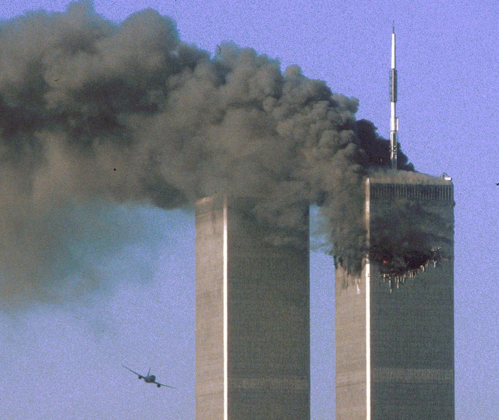 Hijacked United Airlines Flight 175 flies toward the World Trade Center twin towers shortly before slamming into the South tower (L), as the North tower burns, following an earlier attack by a hijacked airliner in New York, U.S., September 11, 2001.