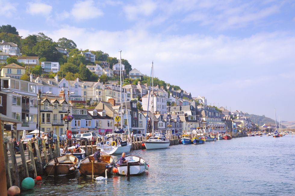 Hillside houses overlooking the harbor and boats along the River Looe in West Looe in Cornwall